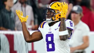 An image of Malik Nabers in his LSU white uniform, putting his hands up questioning something.